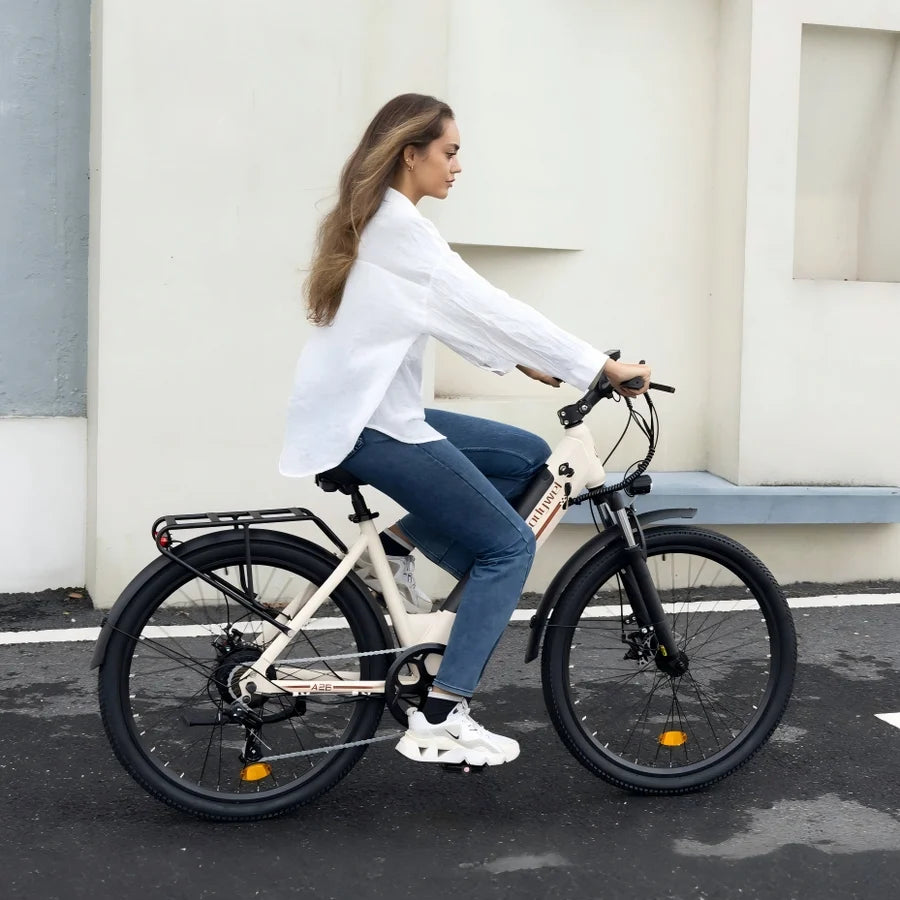 A woman riding a cream-colored step-through electric bicycle with black tires and fenders